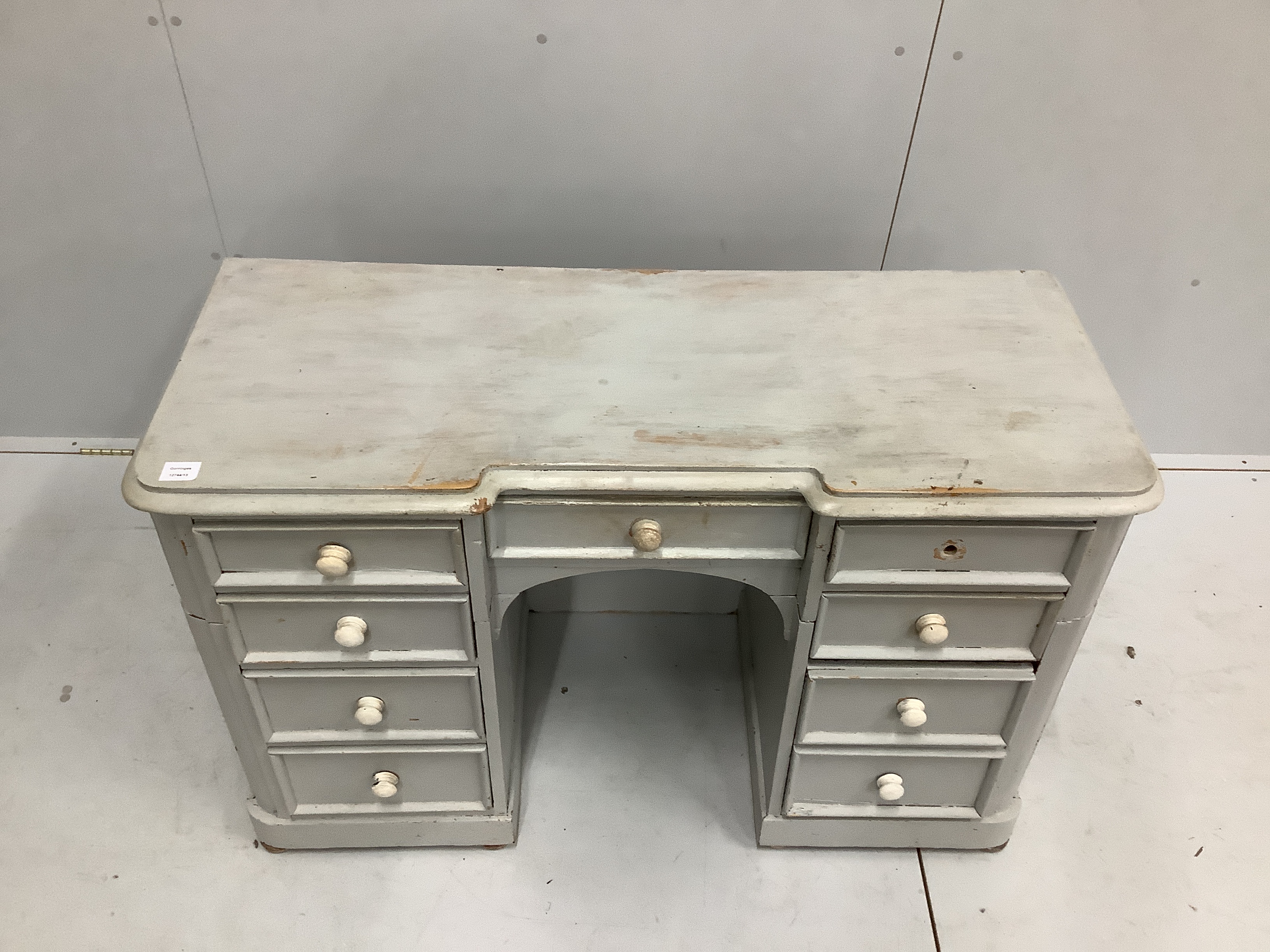 A Victorian pine inverse breakfront kneehole dressing table, cut and later painted, width 122cm, depth 50cm, height 78cm